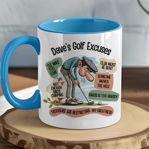 Könnte beinhalten: Weißer Keramikbecher mit blauem Innenraum und Griff. Der Becher zeigt den Text "Dave's Golf Excuses" und eine Cartoon-Illustration eines Golfspielers. Ausreden sind "Tee was too low" und "Grass is too grassy."