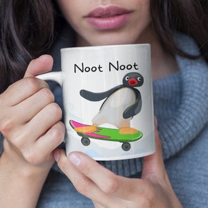 May include: White ceramic mug featuring a cartoon penguin skateboarding with the text "Noot Noot" printed on it.