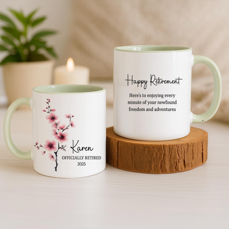 May include: Two white ceramic mugs with light green handles and interiors. One mug features a floral design and the name "Karen" with "OFFICIALLY RETIRED 2025." The other mug says "Happy Retirement."