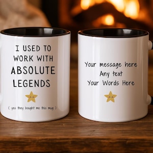 Könnte beinhalten: Zwei weiße Keramikbecher mit schwarzen Griffen und Rändern. Auf einem Becher steht "I USED TO WORK WITH ABSOLUTE LEGENDS" mit einer Stern-Grafik. Der andere Becher hat Platz für individuellen Text.