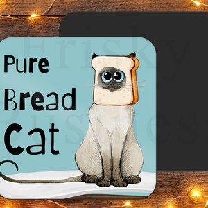 May include: A light blue square coaster with the text "Pure Bread Cat" in black. A cartoon Siamese cat with a slice of white bread on its head is sitting on a white surface.