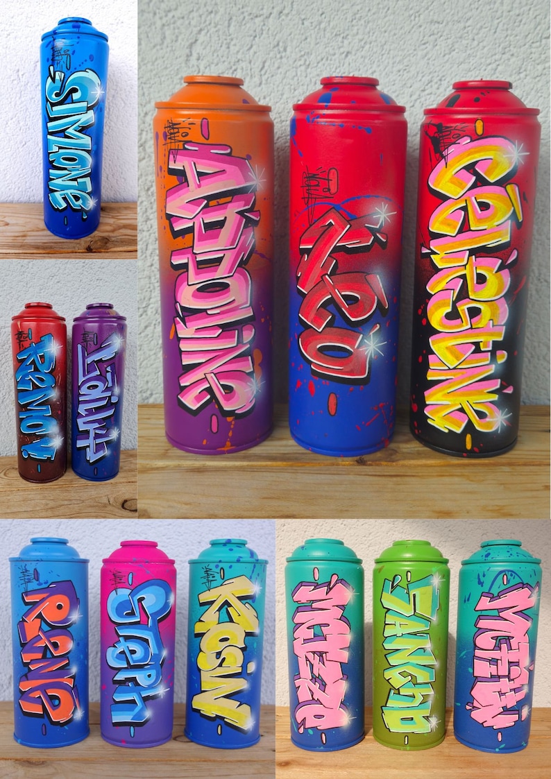 May include: Ten spray paint cans with different names written in graffiti style. The names are Simone,  Adrienne,  Zazu,  Gabriela,  King,  Stern,  Koslov,  Michelza,  Sangrid, and Victoria. The cans are arranged in two rows of five.