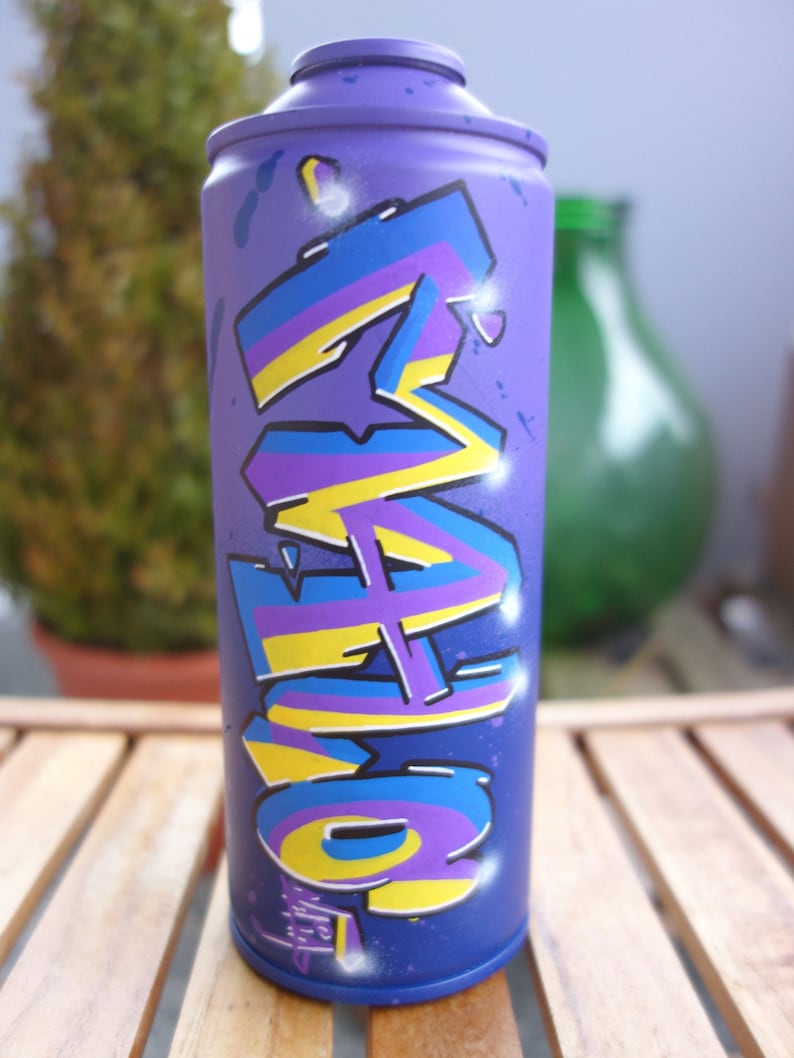May include: A purple spray paint can with a yellow, blue, and purple graffiti design. The design features the word "LOVE" in stylized lettering.