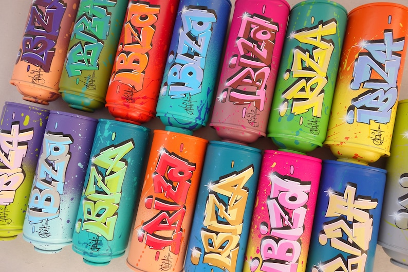 May include: A collection of spray paint cans with the word "IBIZA" written in colorful graffiti style. Each can features a different color scheme and unique lettering.