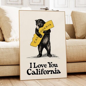 May include: A black bear hugging a yellow outline of the state of California. The bear is standing on a white background. The text "I Love You California" is printed below the bear.