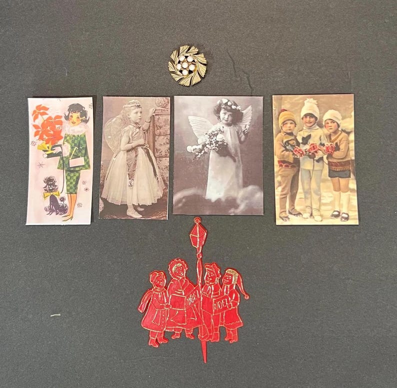 May include: A collection of vintage Christmas-themed ephemera, including postcards and a red die-cut ornament. The postcards feature images of children, angels, and a woman with a dog. A gold-tone brooch with white pearl accents is also included.