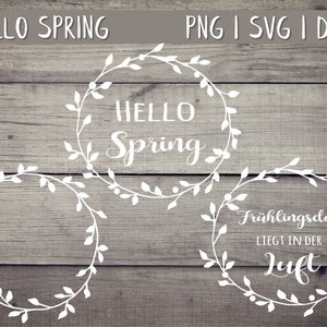 Könnte beinhalten: Drei weiße Kränze mit Blattwerk, jeder mit einem anderen Text. Der obere Kranz sagt "HELLO Spring". Der mittlere Kranz ist leer. Der untere Kranz sagt "Frühlingsduft liegt in der Luft".