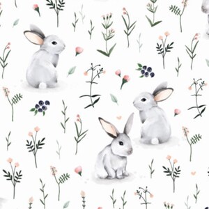 Peut inclure: Un motif r&eacute;p&eacute;titif sur fond blanc pr&eacute;sentant des illustrations &agrave; l'aquarelle de lapins gris clair dans diverses positions, entrem&ecirc;l&eacute;s de tiges vertes d&eacute;licates, de fines feuilles, de petits boutons de fleurs roses et de grappes de baies bleu fonc&eacute;.