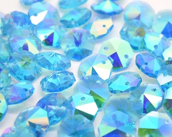 May include: A collection of iridescent blue crystal beads with a faceted design. The beads have two holes for stringing.
