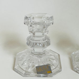 May include: A pair of clear glass candle holders with a cut glass design. The holders are labeled "Mikasa" and "Slovakia".