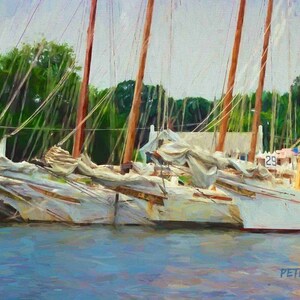 May include: Three white sailboats docked at a marina. The boats are tied together and have their sails down. The boats are in front of a green wooded area. The boat on the right has the number 29 on its side.