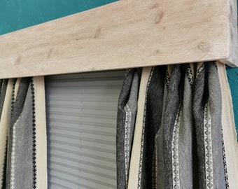 Könnte beinhalten: Eine Holz-Fensterverkleidung mit einer hellen Holzoptik, montiert über einem Fenster mit weißen Jalousien und schwarz-weißen gestreiften Vorhängen.