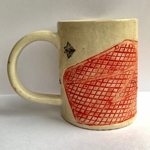 May include: A white ceramic mug with a red and white honeycomb design and a black bee illustration.