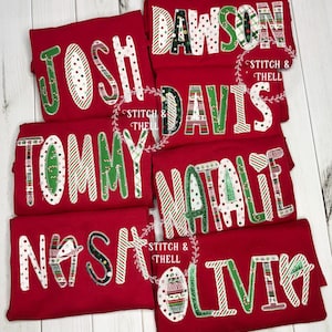 May include: Six red t-shirts with different names on them, each name is made of different Christmas-themed fabric scraps. The names are Josh, Dawson, Davis, Tommy, Natalie, and Olivia.