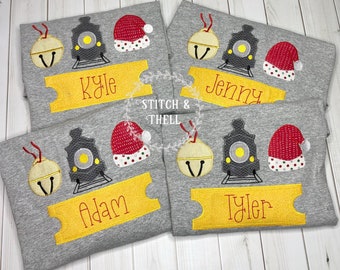 May include: Four gray t-shirts with a Christmas train theme. Each shirt has a yellow ticket with a name on it: Kyle, Jenny, Adam, and Tyler. The shirts also feature a red Santa hat, a gray train, and a yellow bell.