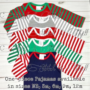 May include: Five long-sleeved baby pajamas in different colors and patterns. The pajamas are striped in red and white, green and white, and gray and red. The pajamas are available in sizes NB, 3m, 6m, 9m, and 12m.