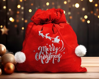 May include: Red velvet Christmas gift bag with a white pom-pom on the drawstring and a silver glitter design that says "Merry Christmas".