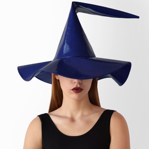 May include: A blue witch hat with a wide brim and a tall, pointed crown. The hat is made of a shiny, glossy material.