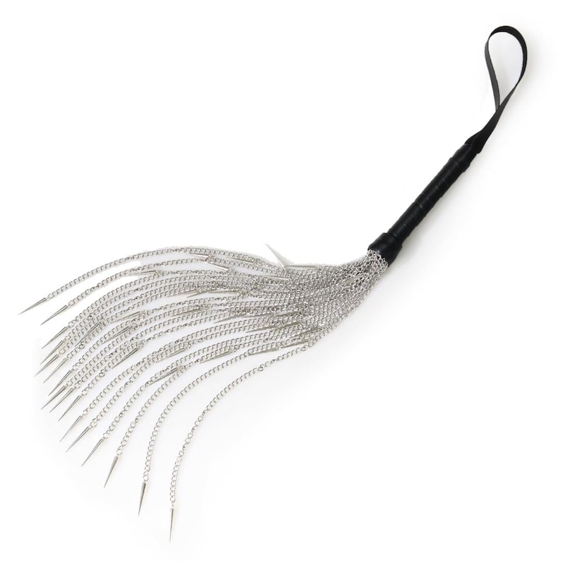 May include: A silver chain whip with a black leather handle. The whip has multiple strands of chain with pointed ends.