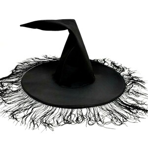 May include: A black witch hat with a wide brim and a tall pointed crown. The brim is trimmed with a fringe of black fabric.