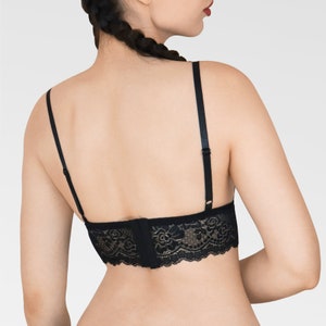 May include: Black lace bralette with adjustable straps. The bralette has a hook and eye closure in the back.