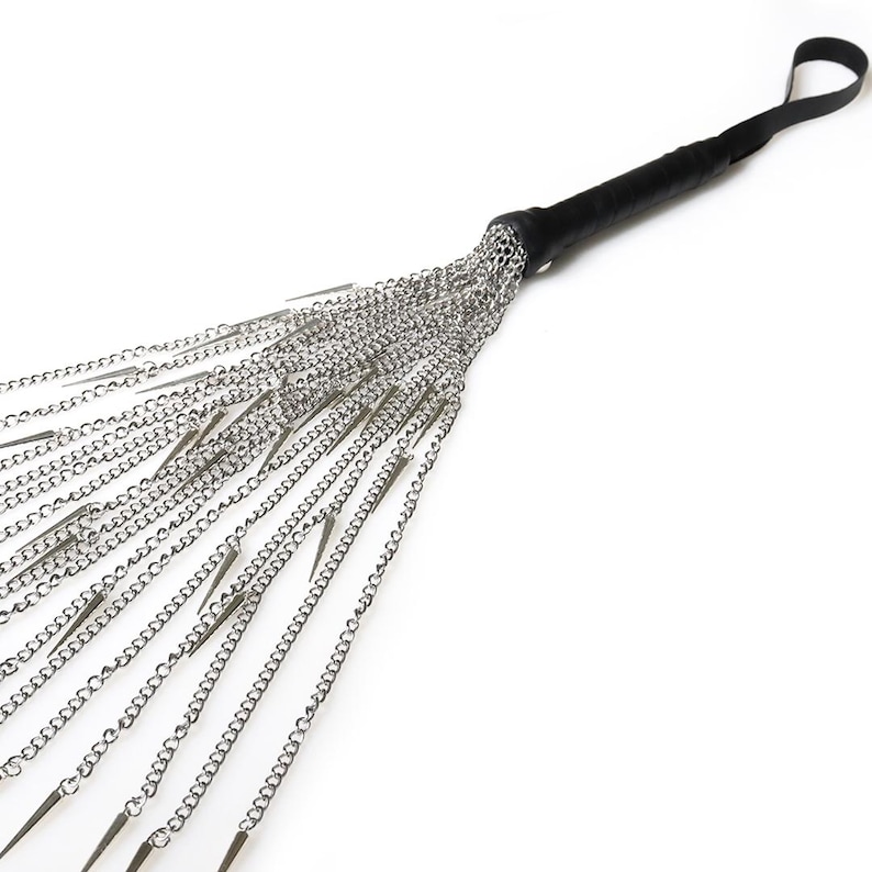 May include: A black leather-handled whip with multiple silver chains and pointed tips.