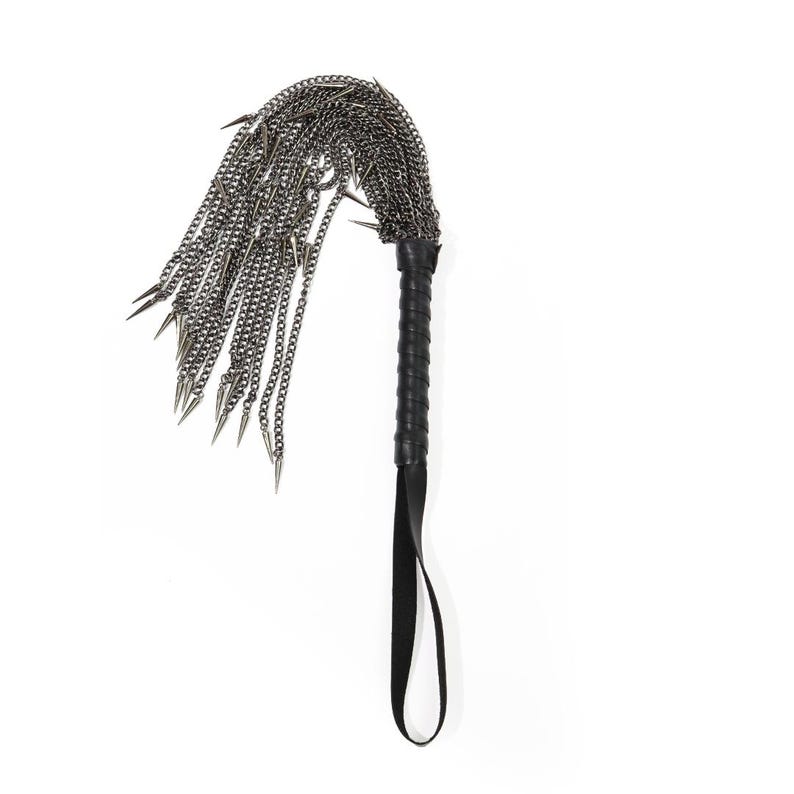 May include: A black leather-handled whip with a silver chain and multiple spikes.