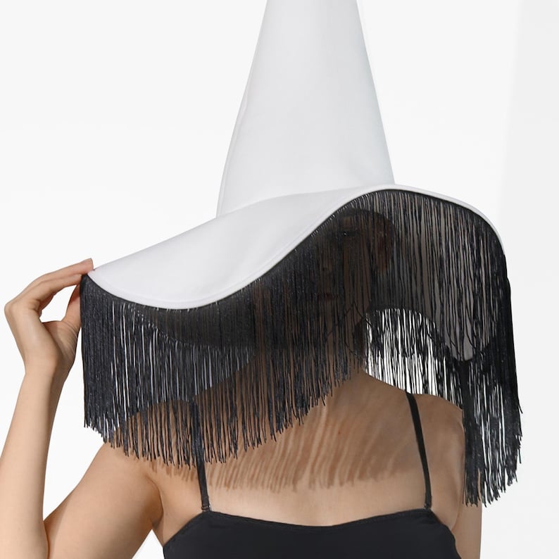 May include: A white witch hat with a wide brim and black fringe trim.
