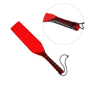 May include: A red leather paddle with black lacing and a black handle. The paddle is about 18 inches long.
