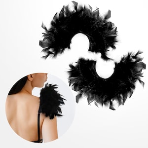 May include: Two black feather shoulder pieces. Each piece is a half-circle shape with feathers that are layered and flowing. The pieces are designed to be worn on the shoulders.