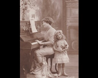 Vintage-Postkarte ∙ Elegante edwardianische Frau, die ihrer Enkelin Klavier spielt