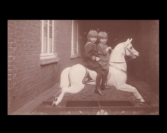 Vintage-Fotokarte ∙ Kinder reiten auf einem Holzpferd