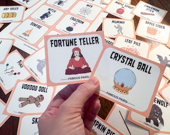 May include: A collection of "Famous Pairs" cards with illustrations and text. One card shows a fortune teller in red, another a crystal ball. Other cards depict a witch, web, and hay bales.