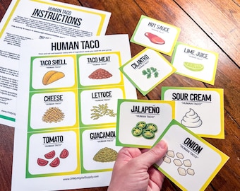 May include: A set of Human Taco game cards and instructions. The cards feature illustrations of taco ingredients like taco shells, meat, cheese, lettuce, tomato, guacamole, hot sauce, cilantro, lime juice, sour cream, jalapeño, and onion. The game is designed for group play.