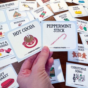 May include: Cards with Christmas and winter-themed illustrations and text, including "Hot Cocoa" with a cup graphic, "Peppermint Stick" with a candy cane, and "Christmas Song" with musical notes. The cards are labeled "Famous Pairs".