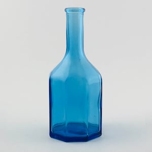 May include: A blue glass bottle with a hexagonal base and a narrow neck.