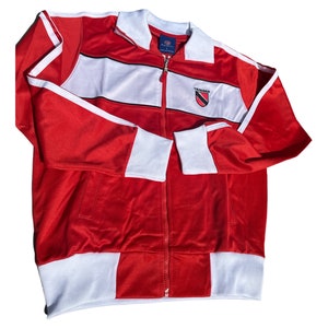 May include: Red and white track jacket with a black zipper and a white logo that says "Trinidad" on the front.
