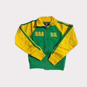 May include: A green and yellow zippered jacket with the word "BRASIL" embroidered on the front.