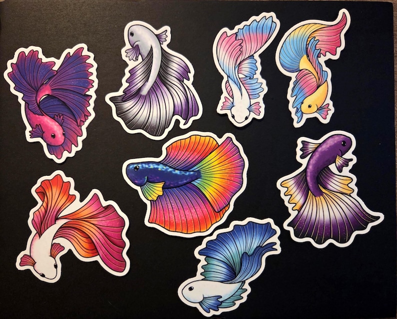 Op de afbeelding: Een verzameling kleurrijke betta vis stickers. Elke sticker heeft een uniek ontwerp met levendige tinten roze, paars, blauw, geel en oranje. De vissen hebben vloeiende vinnen tegen een zwarte achtergrond.