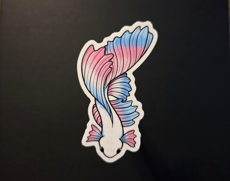 Op de afbeelding: Een sticker met een gestileerde betta-vis met een wit lichaam en roze en blauwe vinnen. De vis is afgebeeld in een sierlijke, gebogen pose, met de vinnen uitwaaierend. De sticker heeft een witte rand.
