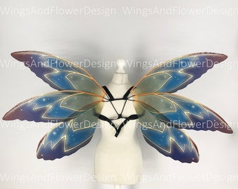 May include: A pair of iridescent butterfly wings with a blue, purple, and gold color scheme. The wings have a starry pattern and are attached to a black harness.