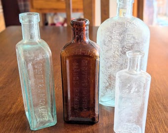 Lot of 4 Vintage 6"-8.5" tall glass medicine bottles. Lydia Pinkhams, Drs Greene, Kuhlmans, Dr. Glovers Imperial