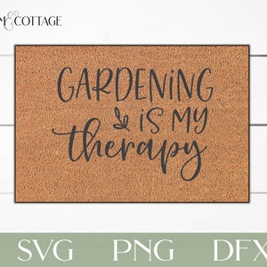 May include: A brown doormat with the text "Gardening is my therapy" in black script font. The text is centered on the doormat and is surrounded by a brown, textured background.