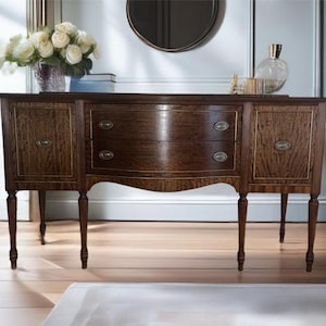 May include: A dark wood sideboard with three drawers and two doors. The sideboard has a curved front and sits on four legs.