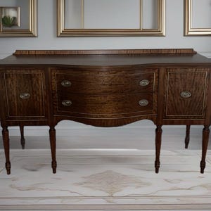 May include: A dark brown wooden buffet with a curved front and three drawers. The buffet has four legs and is sitting on a white rug.