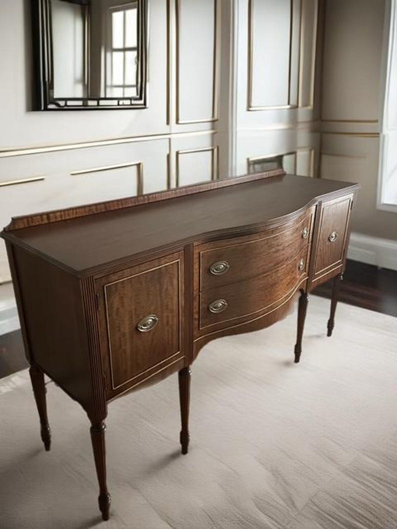 May include: A dark brown wooden sideboard with four doors and two drawers. The sideboard has a curved front and sits on four turned legs.