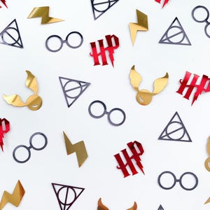 Può includere: Una collezione di ritagli a tema Harry Potter sparsi su una superficie bianca. I ritagli includono fulmini dorati, loghi HP rossi, occhiali neri, boccini d'oro alati e simboli dei Doni della Morte grigio scuro.
