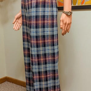 Op de afbeelding: Wijde, geruite broek met een ruitpatroon in blauw, grijs, oranje en rood. De broek heeft een omslagen zoom en is gemaakt van een zachte, comfortabele stof.
