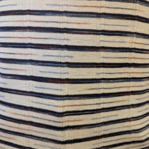 May include: White fabric with thin horizontal stripes in navy blue, light blue, and brown.