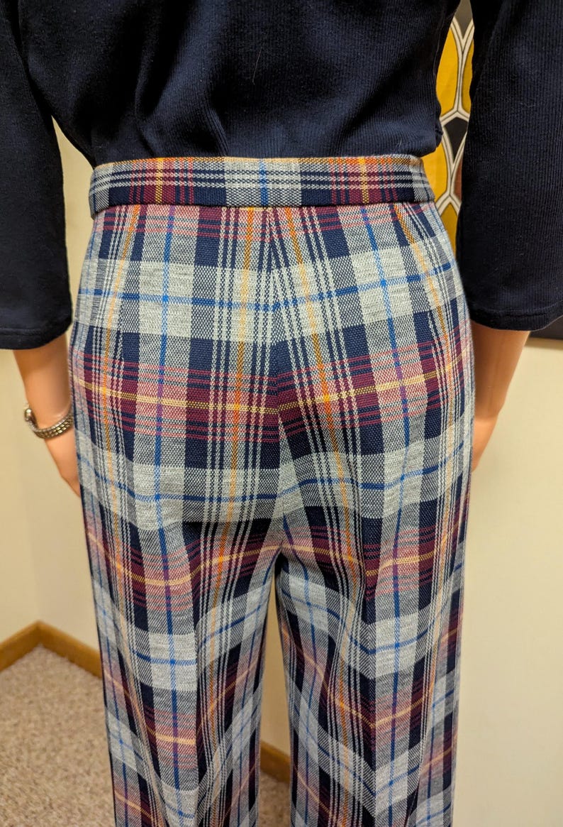Op de afbeelding: Een wijde broek met een geruit patroon in tinten blauw, grijs, rood en oranje. De broek heeft een hoge taille en een ontspannen pasvorm.